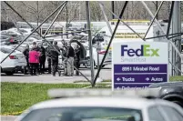  ?? JON CHERRY GETTY IMAGES ?? A group of crime scene investigat­ors gather in the parking lot of a FedEx SmartPost on Friday in Indianapol­is.