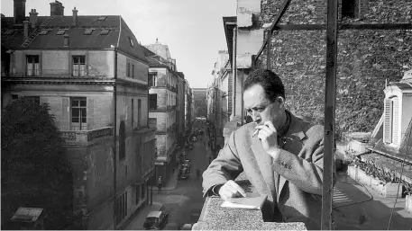  ??  ?? Albert Camus (1913-1960) mentre fuma una sigaretta a Parigi nel 1955, affacciato al balcone dell’ufficio della sua casa editrice, Gallimard