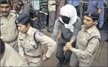  ?? ASSOCIATED PRESS ?? A Swiss woman (center), who, according to police, was gang-raped by a group of four men while touring by bicycle with her husband, is escorted Saturday by policewome­n for a medical examinatio­n at a hospital in Gwalior, in central India.