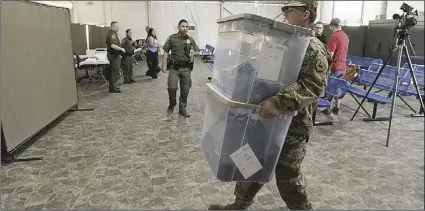  ?? PHOTO RANDY HOEFT, YUMA SUN ?? A soldier with the U.S. Army carries boxes marked “Boys Shoes” and “Mens Shoes” into one of the migrant processing pods at the U.S. Border Patrol Yuma Sector headquarte­rs on June 28.