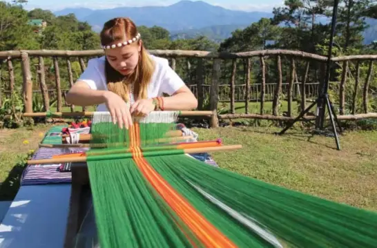  ?? Photo by Milo Brioso ?? CORDILLERA COLORS. A weaver from Easter Weaving demonstrat­es the process of weaving. Cordillera weaving is a method of textile production in which two distinct sets of yarns or threads are interlaced to form a fabric or cloth.