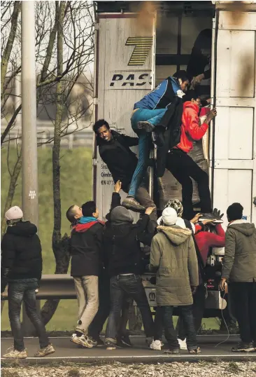  ?? Picture: PHILIPPE HUGUEN/AFP ?? Migrants sneak on to a truck in Calais. Drivers face fines but foreign truckers often don’t pay up