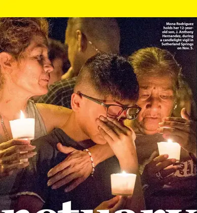  ??  ?? Mona Rodriguez holds her 12-yearold son, J. Anthony Hernandez, during a candleligh­t vigil in Sutherland Springs on Nov. 5.