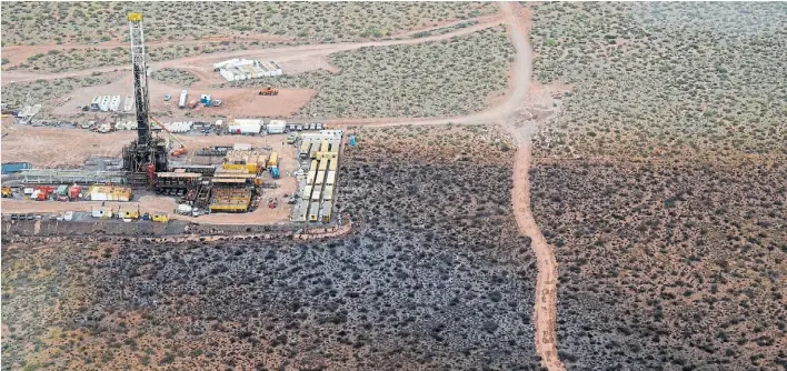  ?? FOTO: YAMIL REGULES. DIARIO RIO NEGRO ?? La mancha negra desde el aire. En tono muy oscuro, las cinco hectáreas más afectadas por el derrame. Al lado, el campamento de operarios.