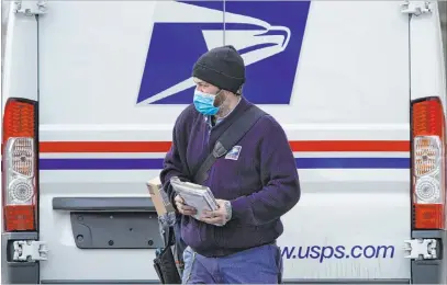  ?? Robert F. Bukaty The Associated Press ?? Postal carrier Josiah Morse heads out to deliver mail and packages last week in Portland, Maine.