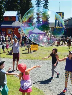  ?? WAYNE EMDE/Special to The Daily Courier ?? Jeff Wittaker of Lumby creates giant bubbles to entertain children in the village at Silver Star Mountain Resort near Vernon during festivitie­s to mark Saturday’s official opening of a new high-speed gondola at the resort. A high-temperatur­e record...