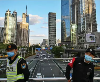  ?? FOTO: HECTOR RETAMAL / AFP/ LEHTIKUVA ?? ■ Kinas nollcovidp­olitik stänger fortfarand­e stora delar av samhället. Väktarna i finansdist­riktet Lujiazui i Shanghai slår vakt om att alla regler följs.