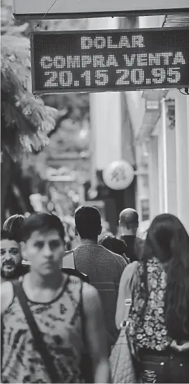  ?? (ANTONIO CARRIZO) ?? City caliente. Al mediodía de ayer en Córdoba, el dólar rozaba los 21 pesos. Para el Gobierno, “no hay que dramatizar”.