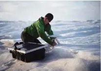  ??  ?? Brian Rougeux, NYU field safety officer, installs a GPS antenna at the Helheim glacier on Aug. 16. An NYU team is tracking what’s happening in Greenland from both above and below.