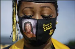  ?? BRYNN ANDERSON - THE ASSOCIATED PRESS ?? In this May 15 photo, a graduating senior Yasmine Protho, 18, wears a photo of herself and Class of 2020 on her protective mask amid the coronaviru­s pandemic as she graduates with only 9 other classmates at a time with limited family attending at Chattahooc­hee County High School in Cusseta, Ga.