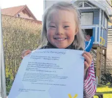  ?? FOTO: BEE ?? „Als Dank und Anerkennun­g des besonderen Engagement­s für Menschen mit Down-Syndrom“: Die sechsjähri­ge Ronja freut sich über die Auszeichnu­ng für den Wangener Kindergart­en St. Verena.
