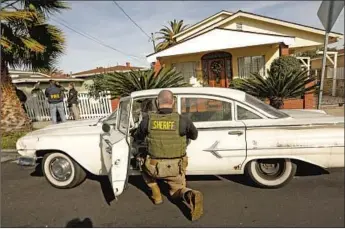  ?? Carolyn Cole Los Angeles Times ?? DEPUTIES search the car of Paul Flores in February. Flores on Wednesday was charged with firstdegre­e murder in the Kristin Smart case. Police said he was suspected of assaulting other women as well.