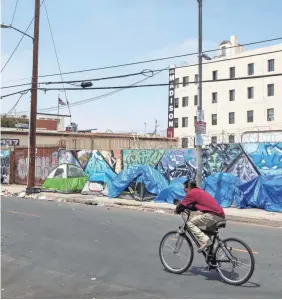  ?? JEFF LEWIS/AP ?? In Los Angeles, thousands of homeless people have set up camps along the street, bed down in cars or sleep out in the open, without basic necessitie­s such as bathrooms and running water.