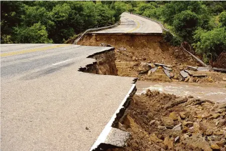  ?? Associated Press file photo ?? The Biden administra­tion grants will fund 80 projects to shore up the nation’s infrastruc­ture against the harmful impacts of climate change, such as this flood damage to a highway in Cisco, Texas, in 2016.