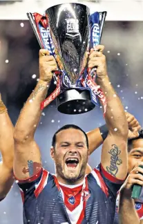  ??  ?? Night of glory: Sydney Roosters’ Boyd Cordner lifts the World Club Challenge trophy and (far left) Brett Morris holds off Wigan’s Thomas Leuluai to complete his hat-trick of tries as the Roosters won the title for a record-equalling fourth time