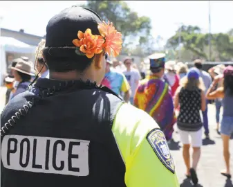  ?? Nic Coury / Special to The Chronicle ?? Monterey police Officer Lidio Soriano wears flowers in his hair Saturday as he patrols the grounds of the 50th anniversar­y gathering of the Monterey Internatio­nal Pop Festival.
