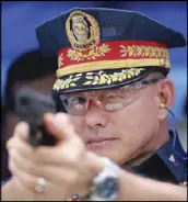  ?? MICHAEL VARCAS ?? PNP chief Director General Oscar Albayalde takes aim during a ceremonial shoot at the formal turnover of 25 patrol cars and 100 assault rifles by the Quezon City government at Camp Karingal yesterday.