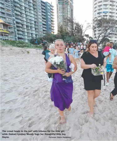  ?? Pictures: Glenn Hampson ?? The crowd heads to the surf with tributes for the little girl, while (below) Lyndsey Moody hugs her thoughtful little boy Dayne.