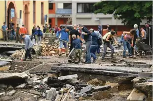  ?? Foto Ina Fassbender/AFP ?? Skupinsko čiščenje posledic poplav v Bad Münstereif­lu na zahodu Nemčije