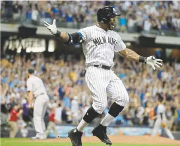  ?? Morry Gash, The Associated Press ?? Milwaukee’s Eric Thames celebrates after hitting a three-run, walk-off home run off struggling Rockies closer Wade Davis on Friday night at Miller Park. The Brewers won 5-3.