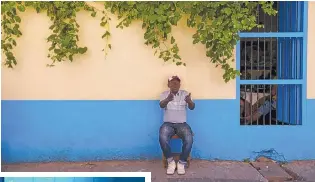  ??  ?? A man sits and converses in Havana.