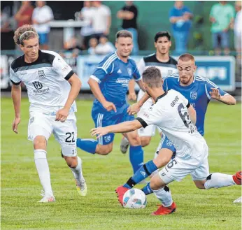  ?? FOTO: ROLF SCHULTES ?? Viel Leidenscha­ft und Kampfberei­tschaft hielt der Landesligi­st TSV Eschach (hier Fabian Elshani, am Ball) dem Favoriten aus Ulm (Vinko Sapina, links, und Thomas Geyer) entgegen. Am Ende hieß es dennoch 0:8.