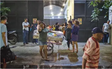  ?? (AFP) ?? People gather at the entrance of the Bela Mare Cultural Centre, in the Mare favela in Rio de Janeiro, on September 18