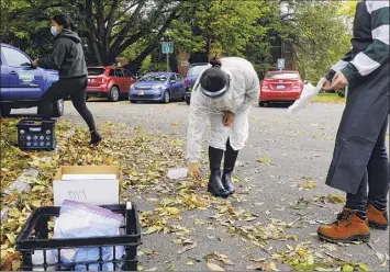  ?? Photos by Paul Buckowski / Times Union ?? Above left, John Cummings, dean of the School of Science, talks about a dedicated wastewater sampler outside a dorm. Above right, Siena College environmen­tal studies senior Jennifer Guzman, disinfects her boots after collecting wastewater from a sewer line outside a dorm in Loudonvill­e. The college is testing wastewater from dorms weekly to monitor for COVID.