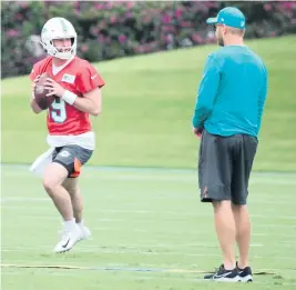  ?? AL DIAZ adiaz@miamiheral­d.com ?? Skylar Thompson, a seventh-round draft choice from Kansas State, works Friday with quarterbac­ks coach Darrell Bevell at Dolphins minicamp.