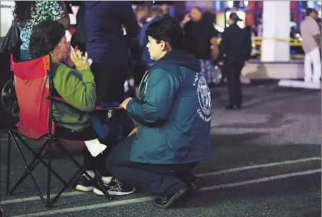  ?? Marcus Yam
Los Angeles Times ?? CRISIS RESPONSE TEAM
member Michelle Paravicini, right, consoles a relative of a person killed in a car crash in Wilmington.