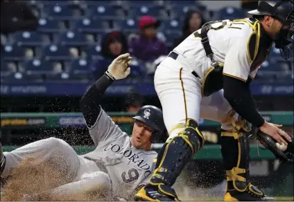  ?? AP Photo/Gene J. PUSKAR ?? Colorado Rockies’ DJ LeMahieu (9) scores on a single by Colorado Rockies’ Chris Iannetta as Pittsburgh Pirates catcher Francisco Cervelli takes the late relay throw during the first inning of a baseball game in Pittsburgh, on Monday.