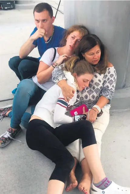  ?? AP ?? Passengers hid behind poles to escape the gunman at Fort Lauderdale’s airport.