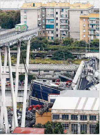  ?? ANTONIO CALANNI / AP ?? A truck (upper left) stopped just in time when a section of the Morandi Bridge in Genoa, Italy, collapsed on Tuesday in a torrential rain amid midday traffic on the eve of a major holiday.