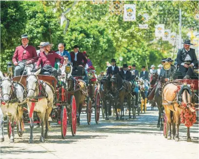  ?? EFE ?? Coches de caballos pasean por una calle de la Feria de Abril en un día marcado por las altas temperatur­as