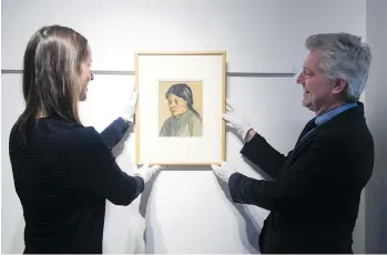  ?? GERRY KAHRMANN ?? Lauren Kratzer, left, and Robert Heffel of the Heffel Fine Art Auction House display an Emily Carr portrait of her friend Sophie Frank on Tuesday in Vancouver. The portrait will be up for auction in May.