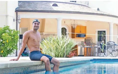  ?? FOTO: HAUPT/DPA ?? Der deutsche Schwimmer Marius Kusch sitzt am Rand eines privaten Pools in San Diego, in dem er dank guter Beziehunge­n derzeit trainieren darf.