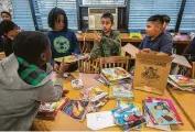  ?? Mark Mulligan / Houston Chronicle ?? Oscar Mendez, center, and other fifth-graders sort library books Thursday at Kelso Elementary.