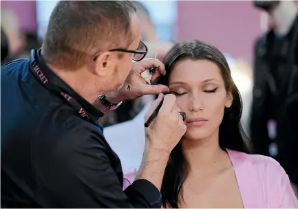  ??  ?? Model Bella Hadid has her makeup done for a runway show in Paris for Victoria’s Secret, whose fortunes are flagging.