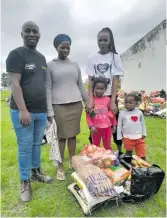  ?? ?? An SA Harvest team member gives a food parcel to a recipient and her children in Redoubt, Mbizana.