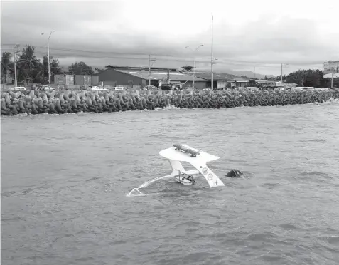  ?? ALDO NELBERT BANAYNAL ?? THE fiBER GLASS BOAT THAT THE CAPITOL OWNS LIES HALF-SUBMERGED AFTER IT TOOK IN SEAWATER REPORTEDLY DUE TO POOR ANCHORAGE. THE CEBU PROVINCIAL GOVERNMENT AND THE TALISAY CITY GOVERNMENT HAVE NOT YET DECIDED WHICH GOVERNMENT UNIT WILL SHOULDER THE...