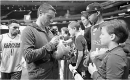  ?? JULIE JACOBSON/ASSOCIATED PRESS ?? Florida coach Mike White signs autographs for fans after practice Thursday at Madison Square Garden in New York. White has directed the Gators to the Sweet 16 in his second season.