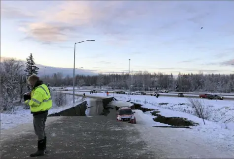  ?? Dan Joling/Associated Press ?? A car is trapped Friday on a collapsed section of the off-ramp of Minnesota Drive in Anchorage, Alaska.