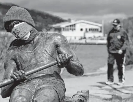  ?? KEITH GOSSE/THE TELEGRAM ?? Someone has placed a mask on the Regatta rower statue on the shore of Quidi Vidi Lake. The Quidi Vidi boathouse is in the background.