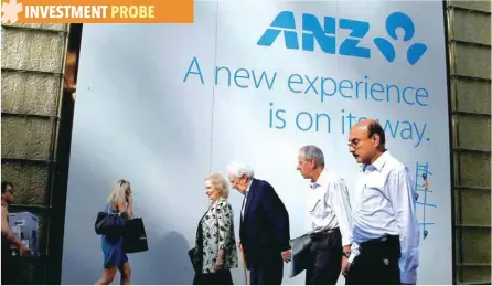  ?? — Reuters ?? People walk past the Australia and New Zealand Bank (ANZ) logo in central Sydney.