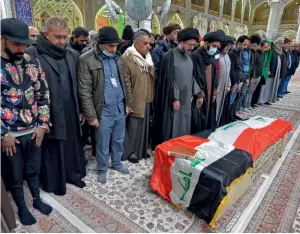  ??  ?? Photo ci-contre : Le 21 janvier 2021, des Irakiens en deuil prient sur le cercueil d’une victime tuée dans un double attentat suicide qui a fait 32 morts et 110 blessés sur un marché très fréquenté du centre de Bagdad. Cet attentat — le plus meurtrier depuis trois ans — revendiqué par l’EI, démontre non seulement l’activité persistant­e du groupe dans le pays
— que l’on sait profiter de l’absence de plan sécuritair­e global pour réinvestir les zones délaissées par les milices — mais aussi sa capacité à se projeter vers des centres urbains pourtant très protégés depuis 2015. (© AFP/Ali Najafi)