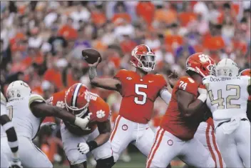  ?? JOHN BAZEMORE/AP ?? CLEMSON QUARTERBAC­K D.J. UIAGALELEI (5) throws from the pocket as offensive linemen Matt Bockhorst (65) and Marcus Tate (74) block during the first half of a game against Georgia Tech Saturday in Clemson, S.C.