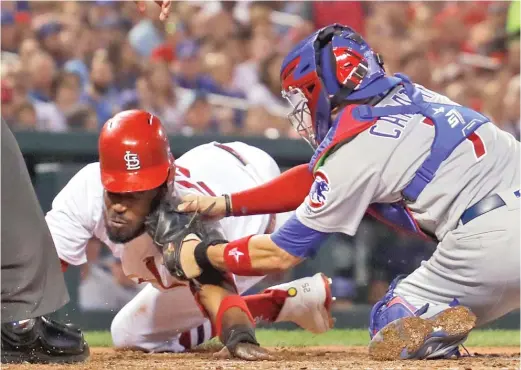  ?? JEFF ROBERSON/AP ?? Cubs catcher Victor Caratini gets the tag on the Cardinals’ Dexter Fowler in the fourth inning Friday before the Cubs lost in the series opener in St. Louis.