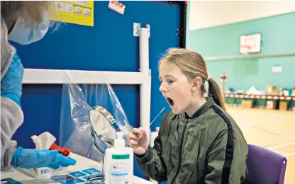  ?? ?? School rules: a girl takes a lateral flow Covid-19 test before being allowed to return to her school in Chertsey