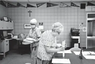  ?? JESSIE WARDARSKI/ASSOCIATED PRESS ?? Marge Berckmille­r, left, and Sister Bridget Reilly prepare student transcript­s Monday to send to other schools after the closure of Quigley Catholic High School in Baden, Pa.