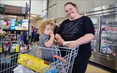  ?? ANDREA PEACOCK/The Daily Courier ?? Rayna Wettberg and her son Blake Daum, 2 1/2, shop Wednesday at the Central Okanagan Community Food Bank’s new location on Enterprise Way.